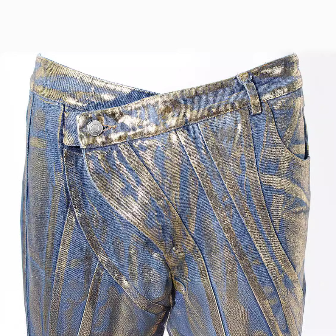 Jeans con detalles dorados, cinturilla con hebilla diagonal, costuras decorativas y acabado con tiras y polvo plateado cepillado.