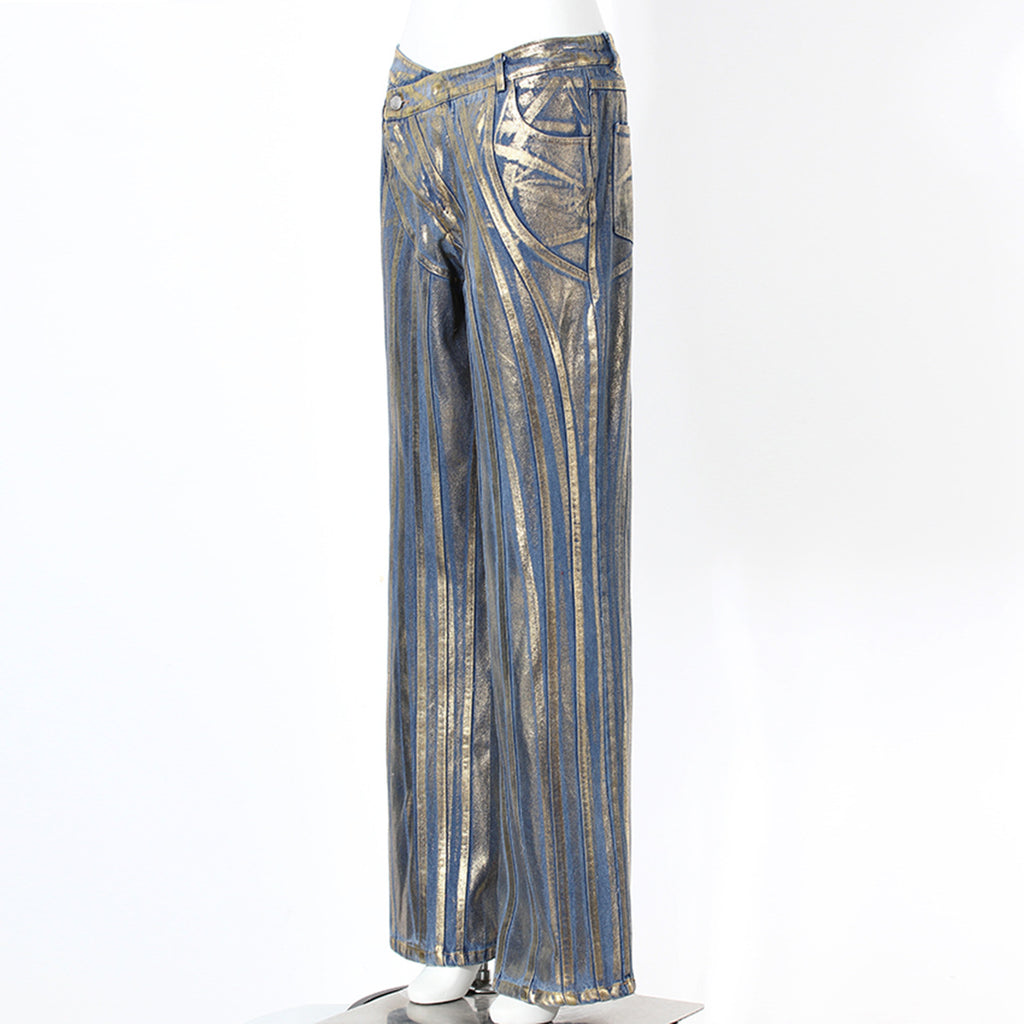 Jeans con detalles dorados, cinturilla con hebilla diagonal, costuras decorativas y acabado con tiras y polvo plateado cepillado.