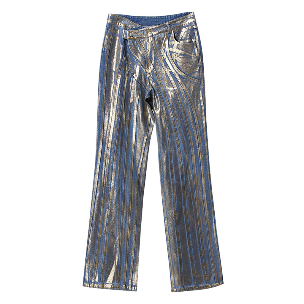 Jeans con detalles dorados, cinturilla con hebilla diagonal, costuras decorativas y acabado con tiras y polvo plateado cepillado.